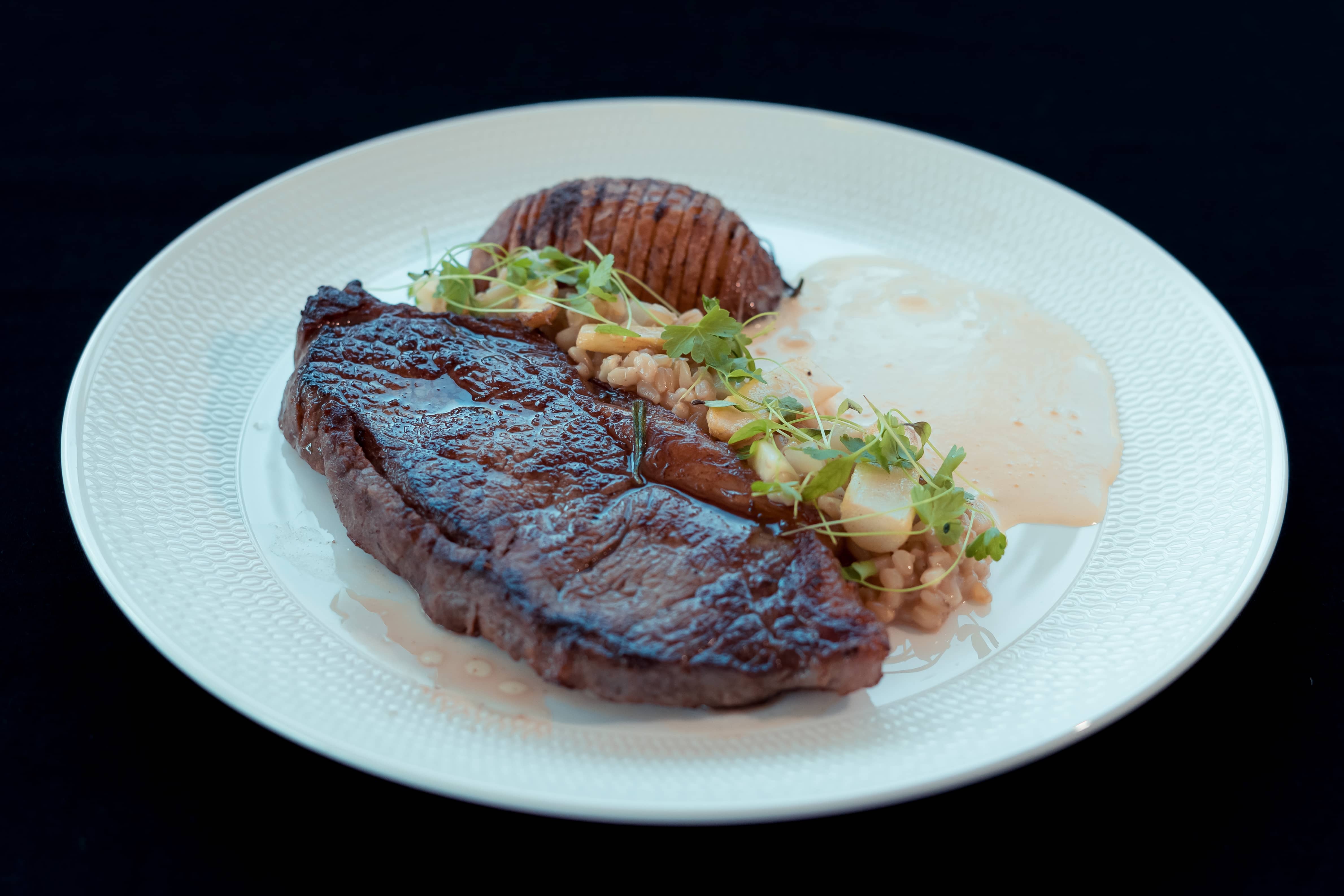 Sirloin Steak with Hasselback Potato, Farro, Asparagus & Hollandaise